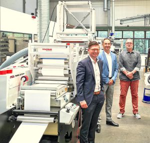 Members of Mark Andy and Barthe Group in front of Mark Andy press